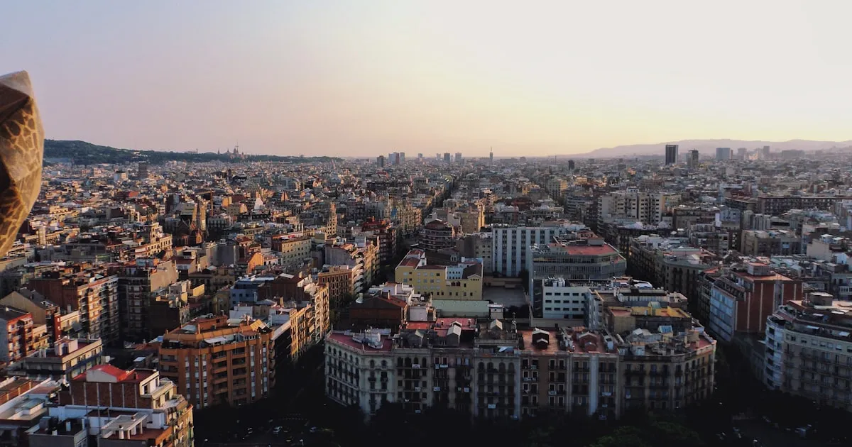 Vista panorámica del Eixample de Barcelona al atardecer con edificios residenciales y cielo dorado